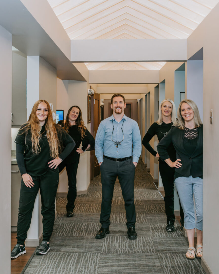 A group photo of five people in a dentist office
