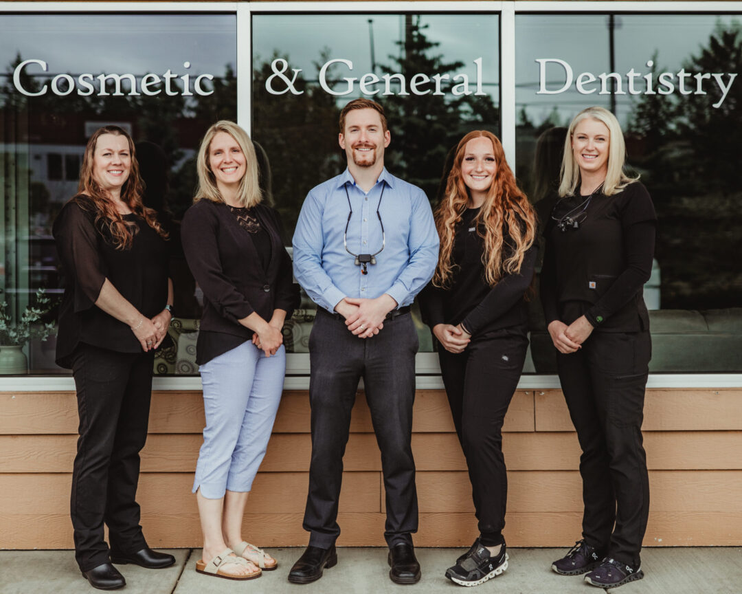 A group photo of people smiling outside a dentist office