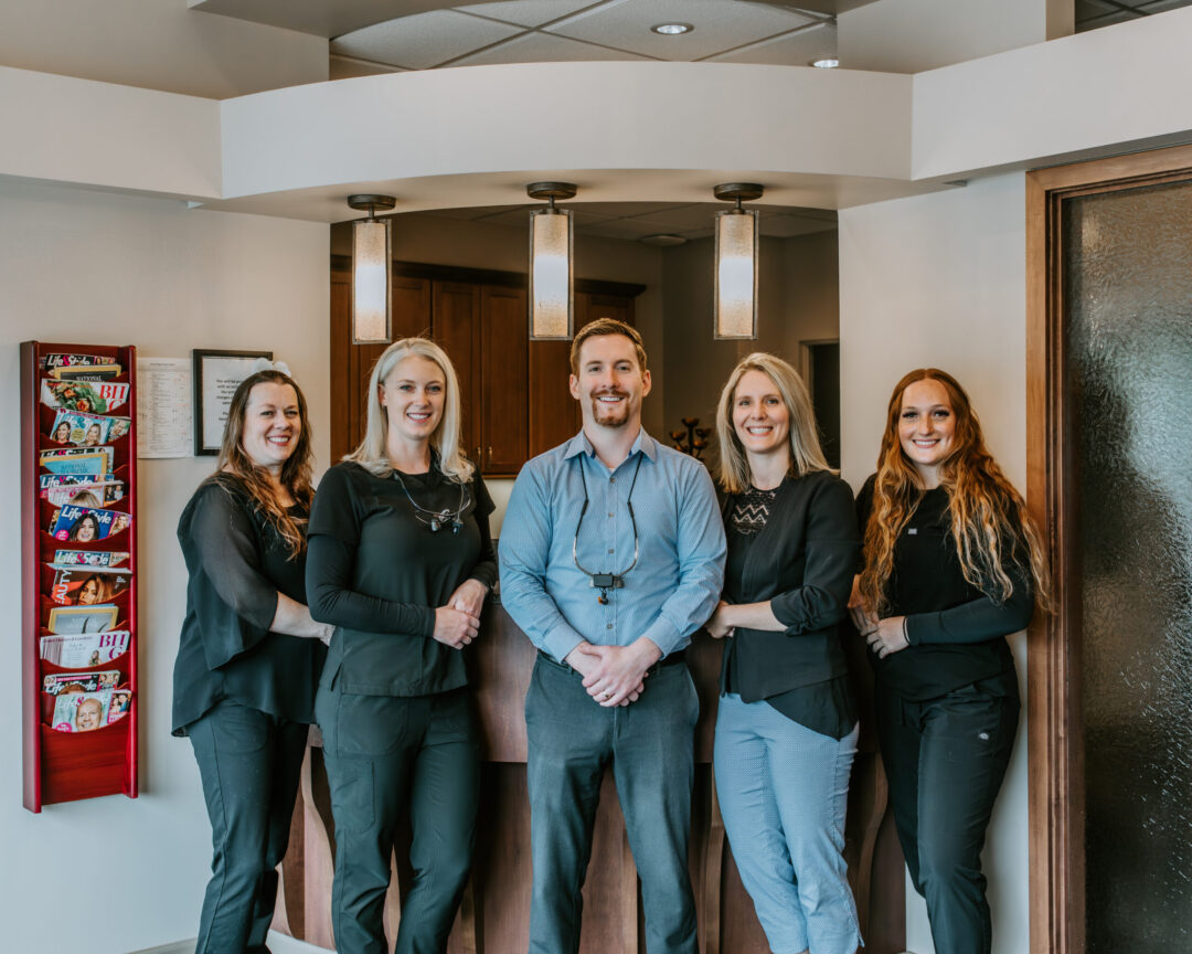 A group photo of five people in a dentist office