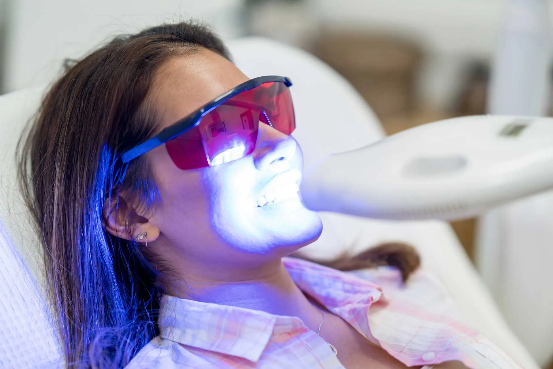 A photo of a woman receiving teeth whitening treatment
