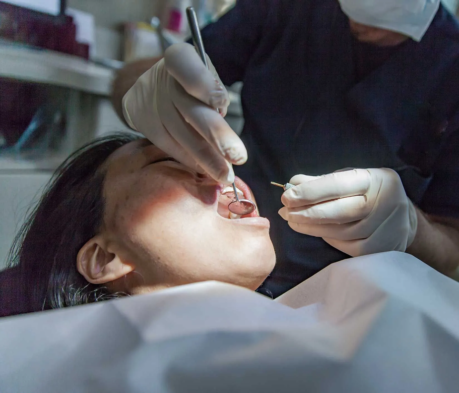 A close up of a person in a dental chair receiving dental treatment